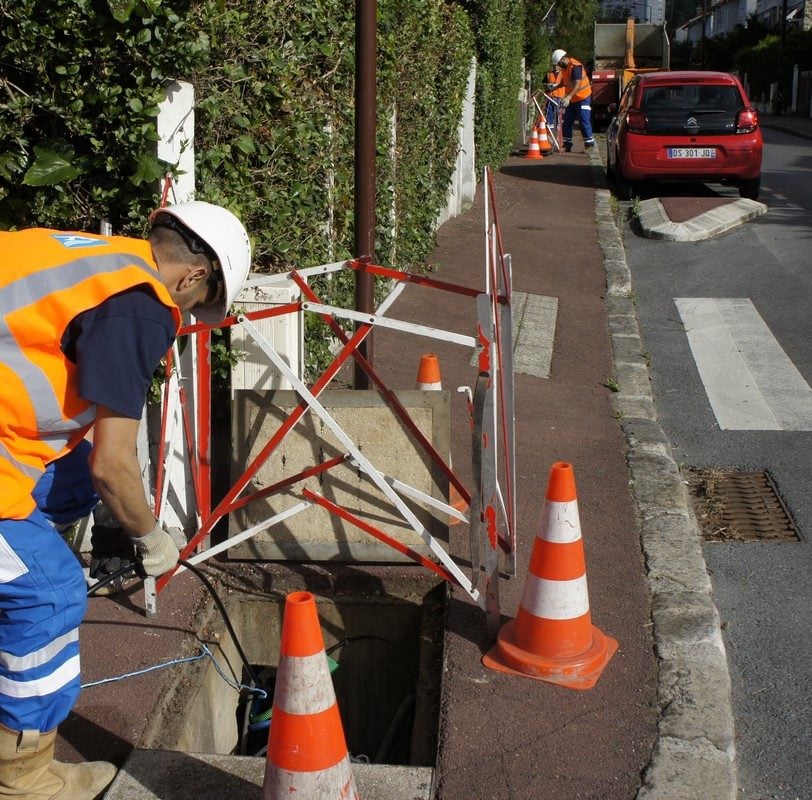 Des opérateurs font passer la fibre optique par deux chambres en même temps.