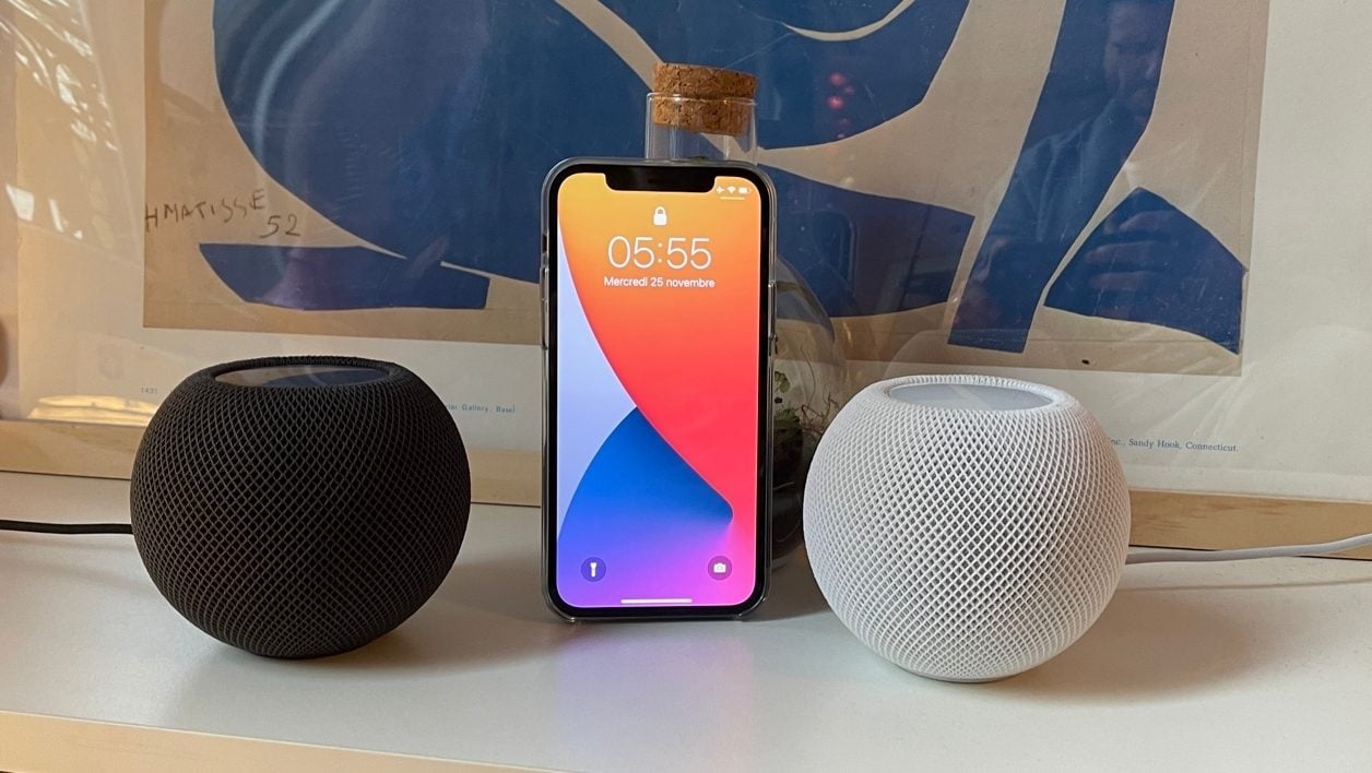 Les HomePod mini à côté de l'iPhone 12.