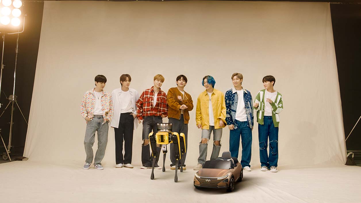 Le groupe BTS posant avec Spot.
