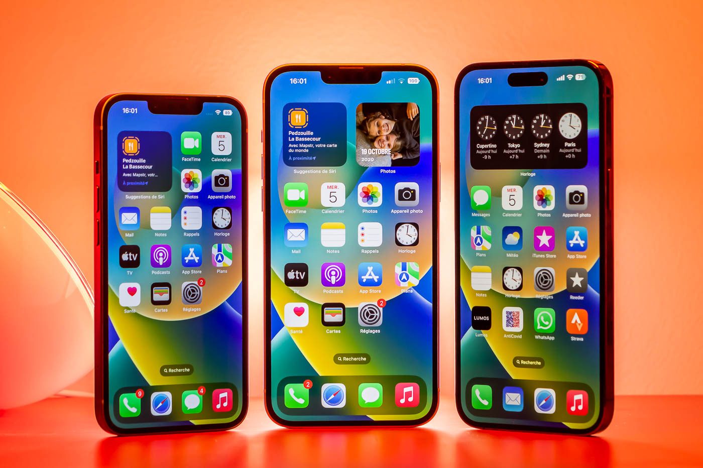 The iPhone 14 Plus is flanked by the iPhone 14 on the left and the iPhone 14 Pro Max on the right.