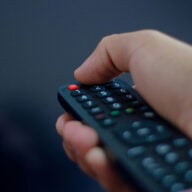 Personne tenant une télécommande TV