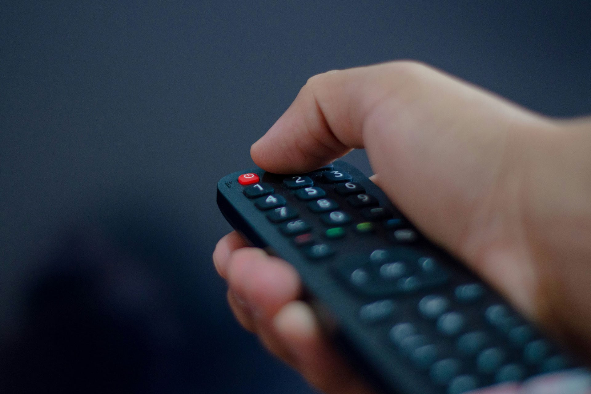 Personne tenant une télécommande TV