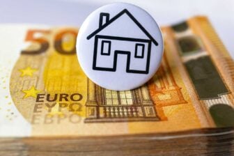 Un bouton avec une maison au-dessus d'une pile d'argent