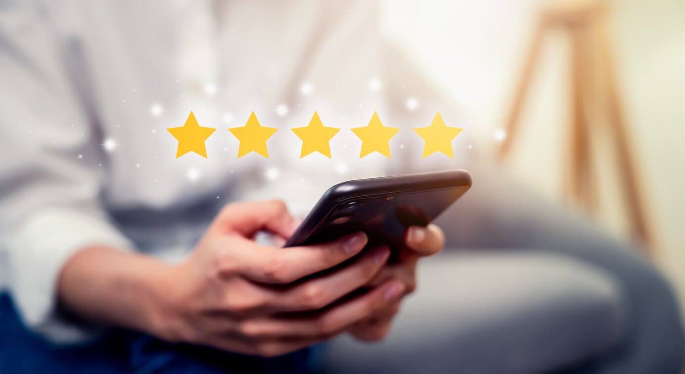 Woman hand holding smartphone and rate your feedback and show five star on application.